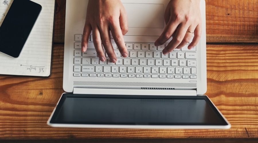 academic writing vs business writing typing on a laptop
